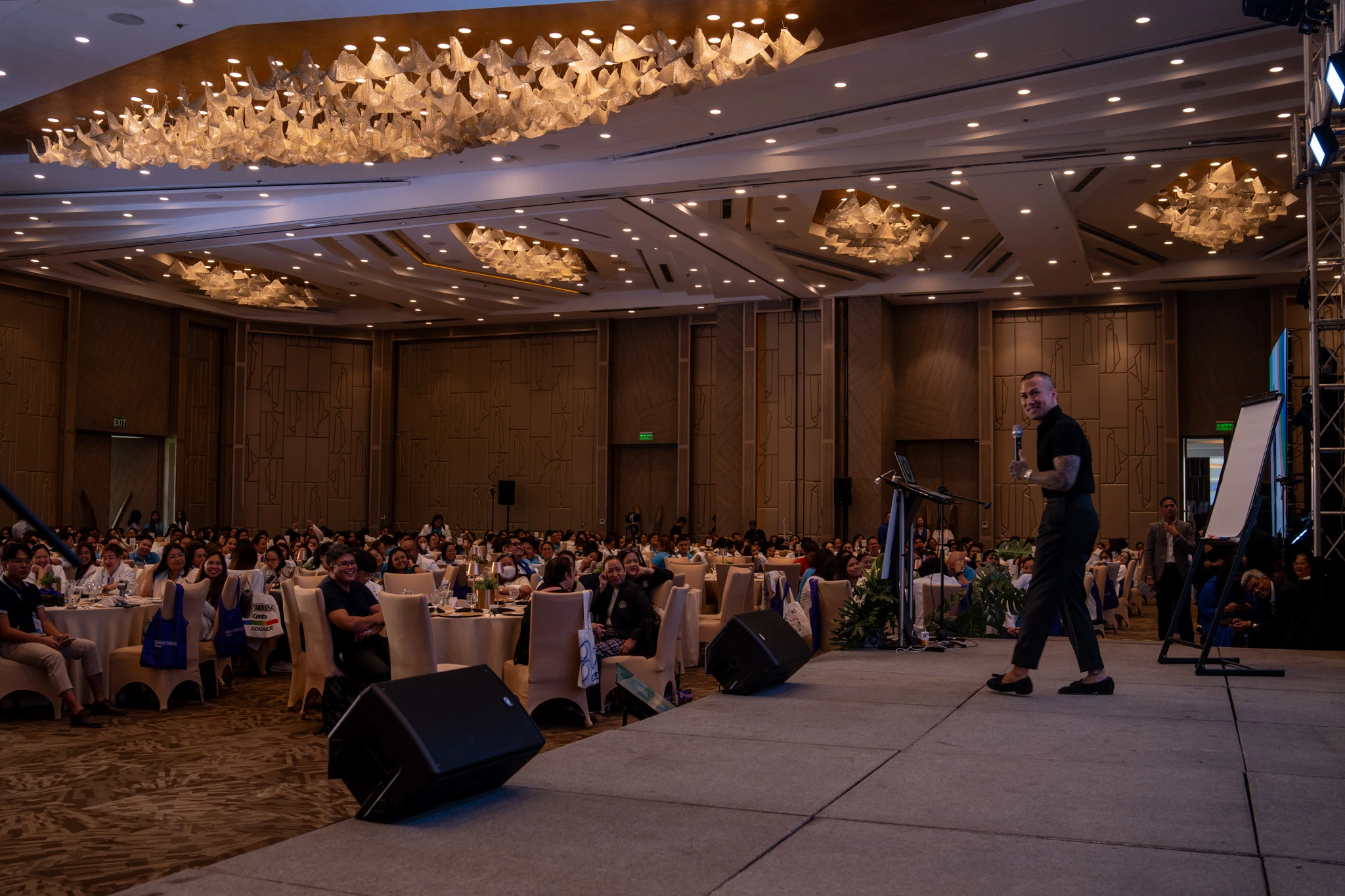 A room of attendees leaning in, lit by the stage at a Power Talks evening